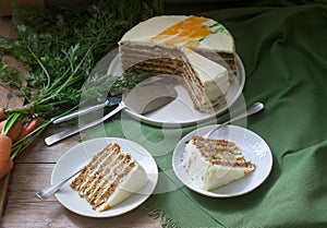 Carrot cake, pieces of cake with curd cream and carrots on a wooden background. Rustic style