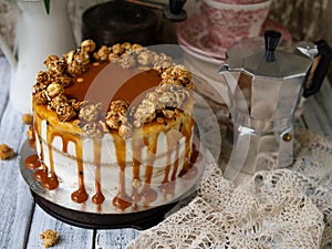 Carrot cake with salted caramel and cheesecake inside, decorated with popcorn and caramel. Retro style, vintage