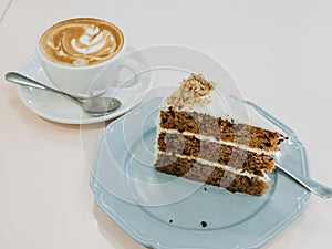 Carrot cake on the table with hot latte for tea time