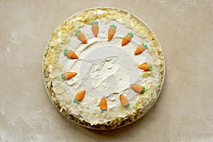 Carrot cake with walnuts an whipped cream, homemade easter cake baking, top view. Whole round cake