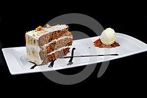 Carrot Cake on a white plate with ice cream on a black background