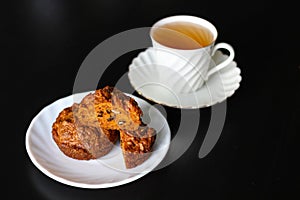 Carrot cakes with walnuts and spices, next to a white porcelain Cup of green tea