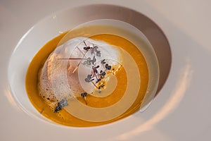 Carrot and chestnut creamy soup served on white plate with wine glass, romantic time on valentines day