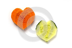 Carrot and cucumber. 2 slices in heart shape isolated on white background. Couple relationship concept. Difference versus similari