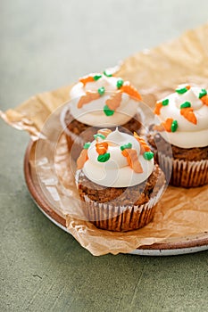 Carrot cupcakes with cream cheese frosting decorated with tiny carrots