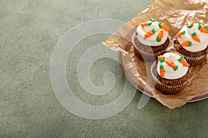 Carrot cupcakes with cream cheese frosting decorated with tiny carrots