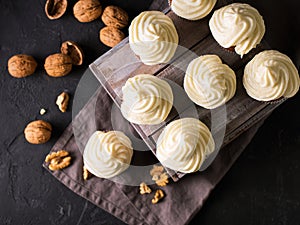 Carrot cupcakes or muffins with nuts on dark background