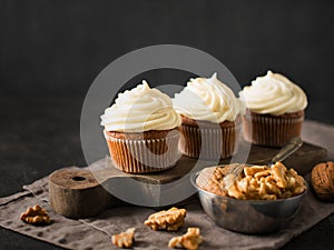 Carrot cupcakes or muffins with nuts on dark background