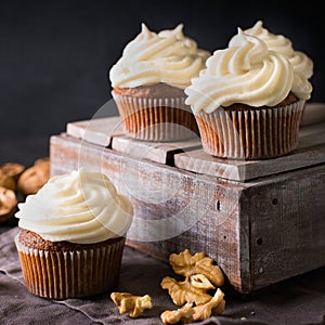 Carrot cupcakes or muffins with nuts on dark background