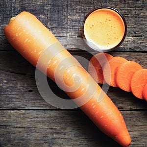 Carrot juice and carrot slices on wood table