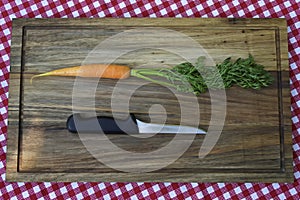 Carrot and knife on wooden board. Minimalism.