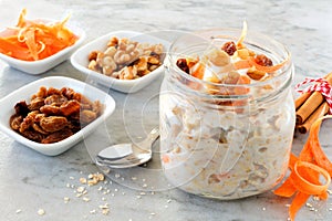 Carrot overnight oats with nuts and raisins in a mason jar on marble