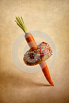 Carrot piercing a doughnut