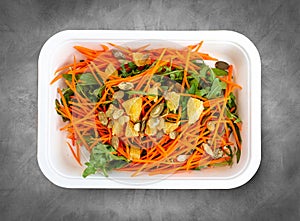 Carrot salad with orange. Healthly food. Takeaway food. Top view, on a gray background