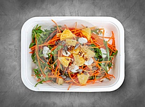 Carrot salad with orange. Healthly food. Takeaway food. Top view, on a gray background