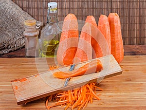 Carrot during shredding on grater for vegetarian carrot salad prepare
