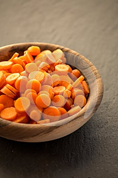 Carrot slices in wooden bowl.