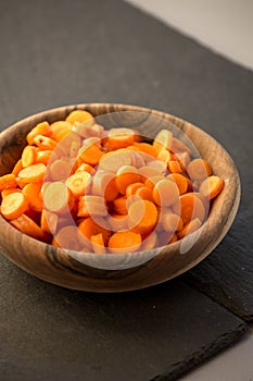 Carrot slices in wooden bowl.