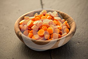 Carrot slices in wooden bowl.