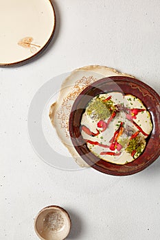 Carrot soup with creamy espuma in dark ceramic bowl. Vegetable cream soup in modern dishware with hard shadow