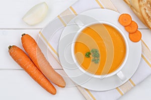Carrot soup with fresh carrots in bowl from above