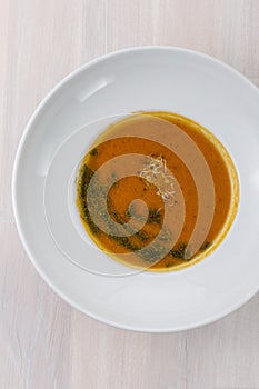 Carrot soup with microgreens and green oil on the table top view