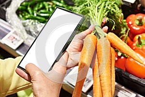 Carrot vegetable in hand and smartphone  white