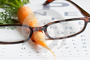 Carrot vitamin A and eye test chart healt medical concept photo