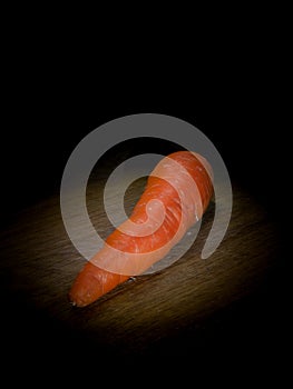 Carrot on wooden board on black background