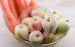 Carrots and apples in a basket.