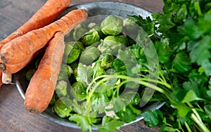 Carrots and Brussels sprouts on wooden background