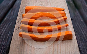 carrots cut into strips set on wood board close up uncooked carrots