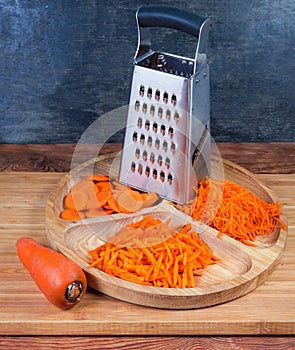 Carrots grated in different ways, whole carrot and kitchen grater