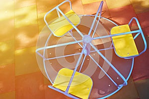 Carrousel for children in the public playground, sunlight effect, top view