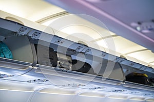 Carry-on luggage in overhead shelf in airplane cabin