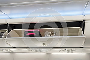 Carry-on luggage in overhead storage compartment on airplane.