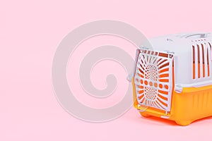 Carrying box for cats and ferrets on a pink background close-up with place for text