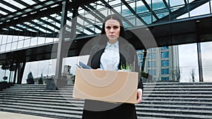 Carrying the Burden of Job Loss Unemployed Woman Outside with Box