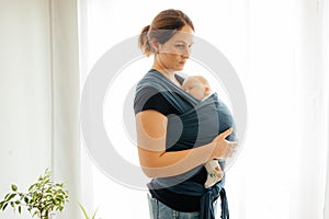 Carrying newborn in baby wrap to comfort him