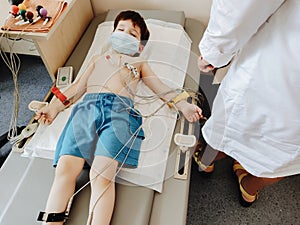 carrying out an electrocardiogram on the chest of a boy during the annual therapeutic examination. Diagnosis of heart