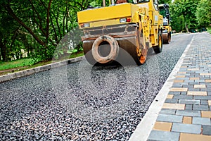 Carrying out repair works: asphalt roller stacking and pressing hot lay of asphalt. Machine repairing road