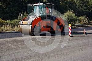 Carrying out repair works: asphalt roller stacking and pressing hot lay of asphalt. Machine repairing road