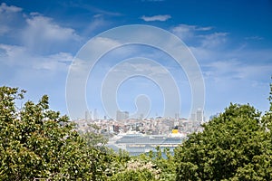 Selective blur on a Cruise ship, a huge boat, seen from afar in front of Beyoglu port and district in istanbul, Turkey