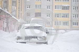 Cars blocked by snow, snow-paralysis of traffic, snow covered street, blizzard, front view, winter weather, work for utility compa photo