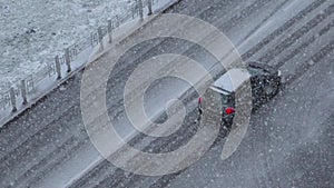 Cars in city amidst a snowy landscape, showcasing a serene and wintry scene. Slow motion