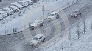 Cars in city amidst a snowy landscape, showcasing a serene and wintry scene. Slow motion