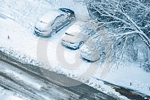 Cars covered with snow in a parking lot in winter