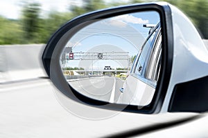 Cars drive along a high road with motion blur background. Sar side mirror with traffic. Car rear view mirror with reflection of