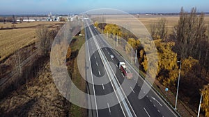 Cars driving along highway on autumn sunny day. Automobile road with markings