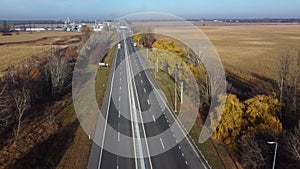 Cars driving along highway on autumn sunny day. Automobile road with markings